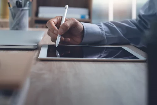 A professional working on a digital tablet with a stylus, indicating a focus on design or digital artistry.