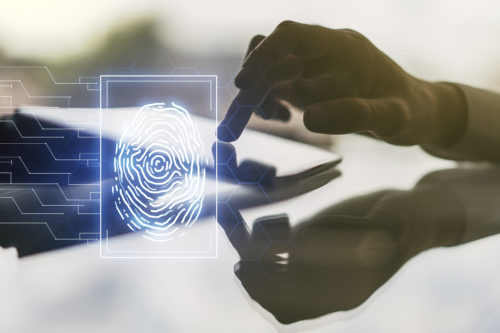 A silhouette of a person's hand interacting with a futuristic biometric fingerprint scanner overlay, symbolizing advanced digital security technology to prevent digital signature fraud.