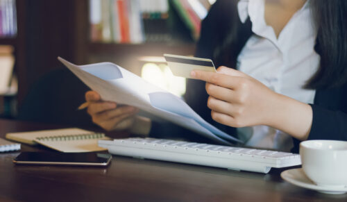 person looking at credit card and document