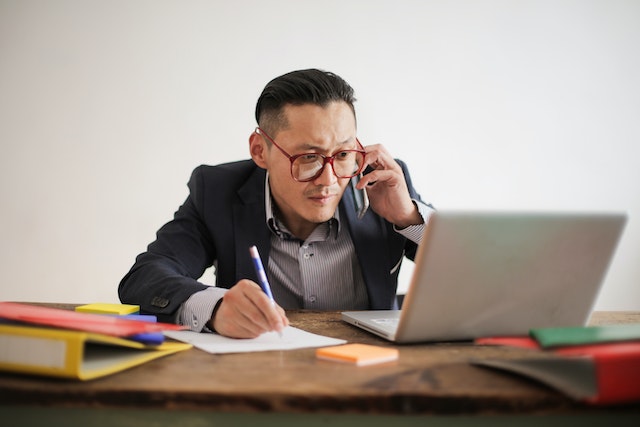 man at computer on phone