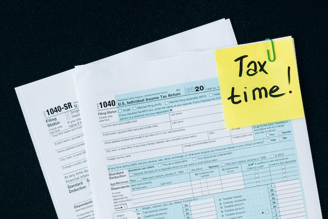tax papers with "tax time!" written on post it note