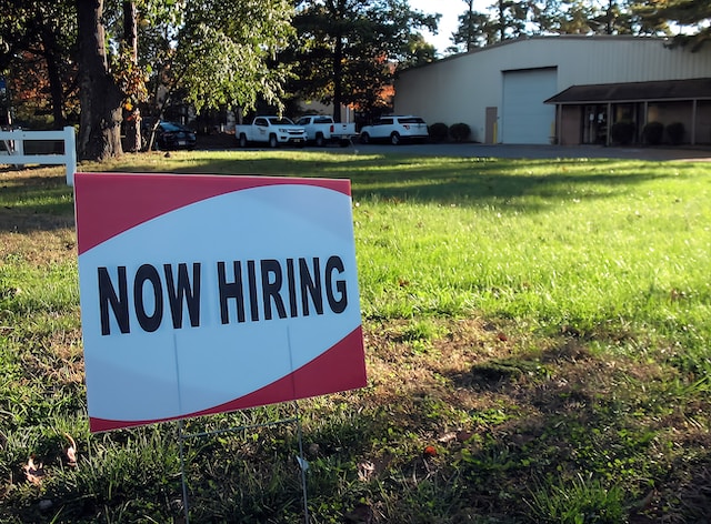 lawn sign with "now hiring" printed
