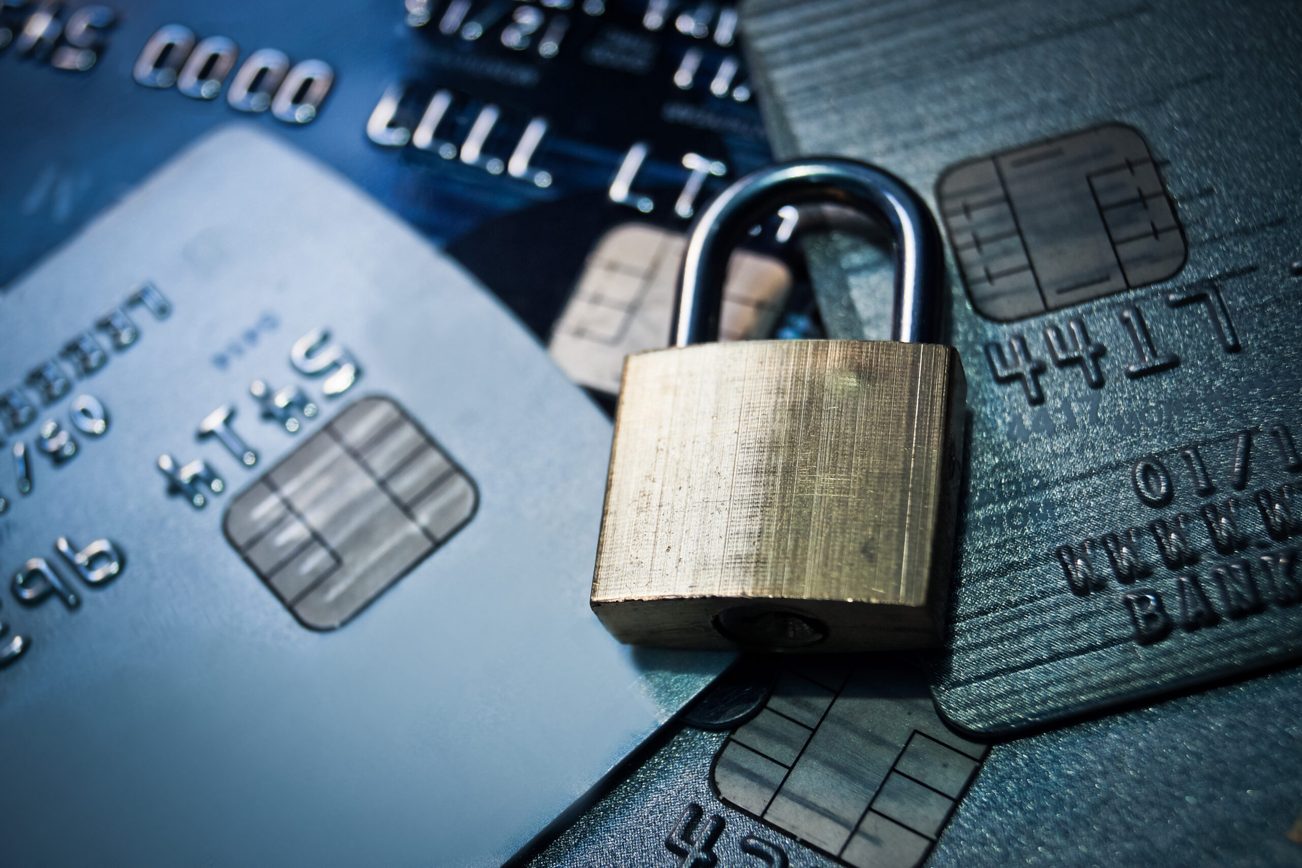A padlock resting on a stack of credit cards, symbolizing financial security and protection against identity theft and fraud.