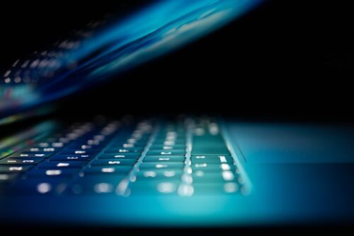 half closed laptop with lit screen